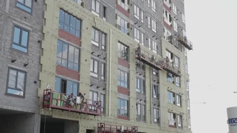 Workers in the construction cradle make cladding Stock Footage 132494243