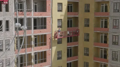 Workers in the construction cradle make cladding Stock Footage 132494275