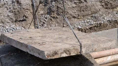 Workers with construction crane cover new water pipes with concrete slabs Stock Footage 107722214