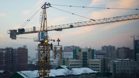 Workers at a construction site collect construction crane at sunset, 4k Video stock 71520723
