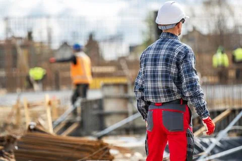 Workers at a construction site during the day in a city setting Stock Photos