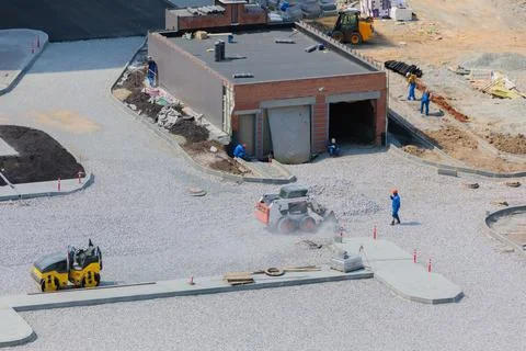 Workers at a construction site leveling debris at the site. Stock Photos