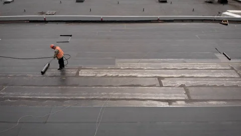 Workers at a construction site. The process of hydro insulation of the roof Stock Footage 112936447