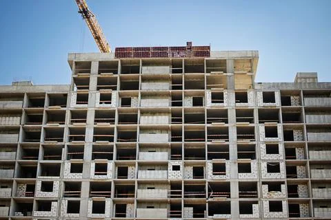 Workers continue the construction of a high-rise building in an urban setting Photos
