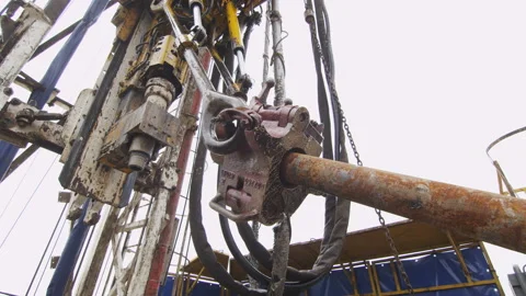 Workers control pipe lifting by oil exploratory drilling machine under cloudy Stock-Footage 93058777