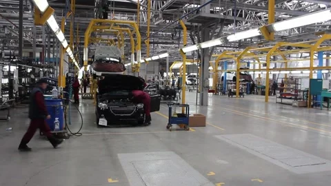 Workers on the conveyor assemble a new car at the car factory. Stock Footage 122335838