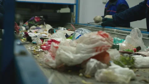 Workers at conveyor sorting garbage at a recycling plant Stock Footage 99930100