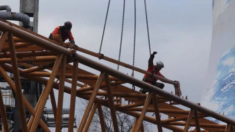 Workers at a crane at the construction site of the coal-fired power station Stock Footage 137572382