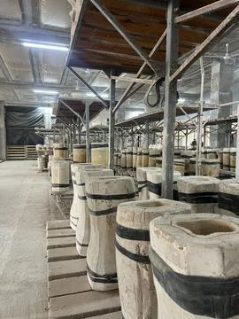 Workers create and store various ceramic pieces made from clay in a large pro Stock Photos