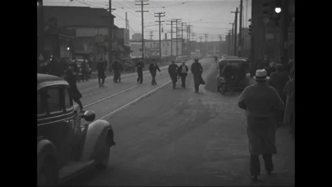 Workers cross the road and disembark from the bus to enter the factory - 1939 Stock Footage 101911317