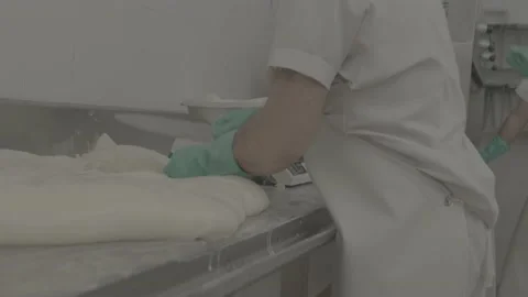 Workers cut and portion cheese for later weighing Stock Footage 222015912