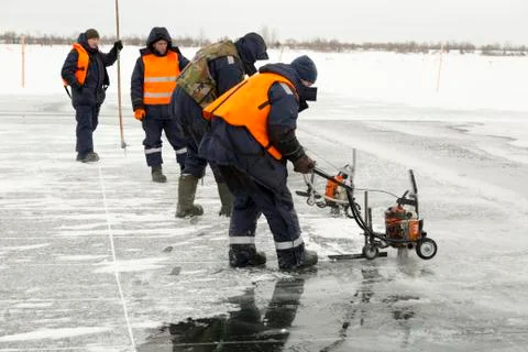Workers cut ice blocks to the size of ice on a frozen lake 写真素材