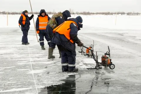 Workers cut ice blocks to the size of ice on a frozen lake 写真素材