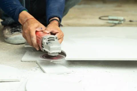 Workers cut the tiles into the shape with electric tile cutter with or angle Stock Photos