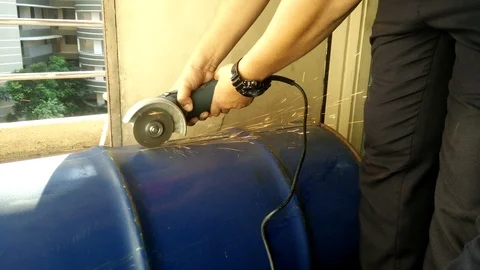 Workers cut the used barrel using the grinder Stock Footage 93012214