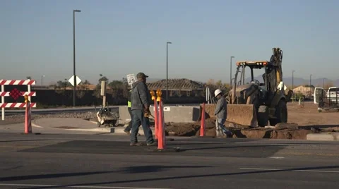 Workers digging trench, caution pylons in road Stock Footage 45482792