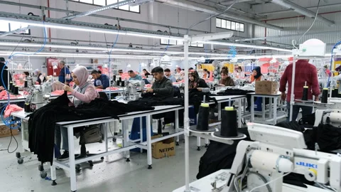 Workers diligently using sewing machines in a textile factory Video stock 325331151