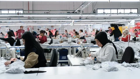 Workers diligently using sewing machines in a textile factory Stock Footage 325337423