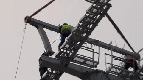Workers direct multi-ton structure on support with help Ka-32. Stock Footage 106607395