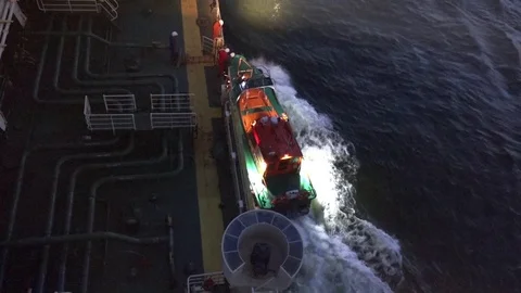 Workers disconnect motorboat from ship side sailing to sea Stock Footage 113093585