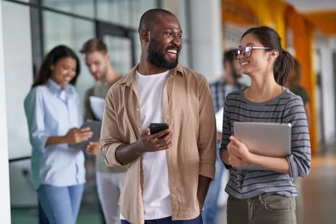 Workers discussing new projects in corridor together Stock Photos