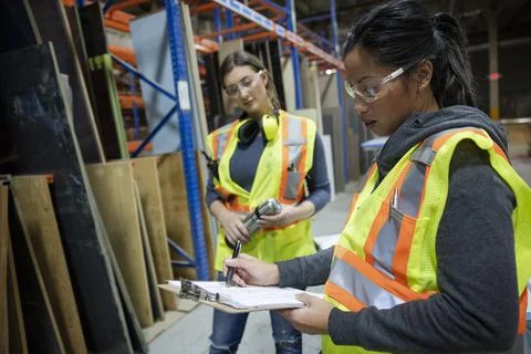 Workers discussing work in distribution warehouse Stock Photos
