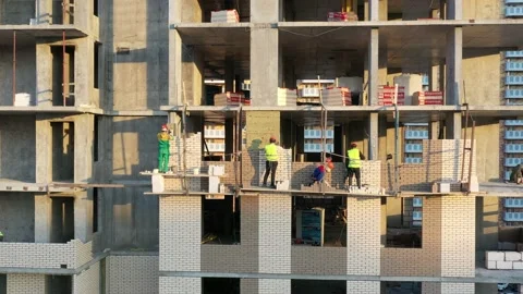 Workers doing brickwork of a new high-rise building with concrete frame Видео 138213075