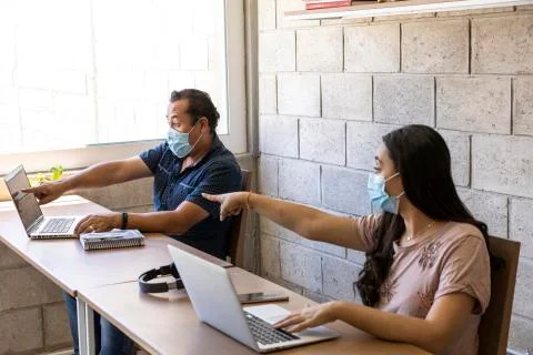 Workers doing office work on computers with social distance Stock Photos
