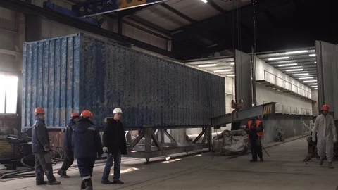 Workers drag the container into the workshop. Stock Footage 104657092
