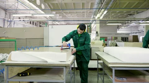 Workers dressed in uniform make a sofa, couch or settee in furniture factory. 4K 库存影片 146141371