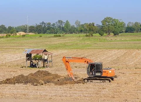 Workers drive backhoe, dig the soil, build ponds. Stock Photos