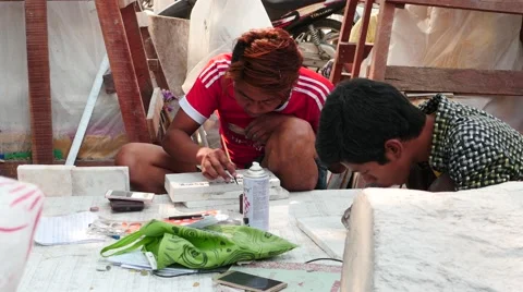 Workers etch and paint the words on marble plates in Mandalay street Stock Footage 61204915