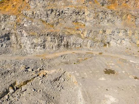 Workers extract granite from the quarry site using heavy machinery. Large roc Stock Photos