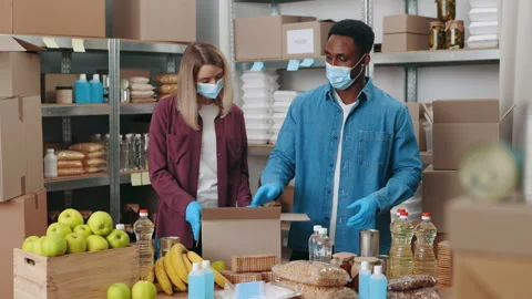 Workers in face masks preparing parcels at food warehouse 스톡 동영상 195731585
