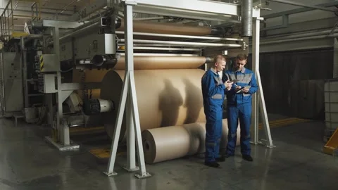 Workers in a factory facility producing corrugated cardboard with a tablet Stock Footage 280789790