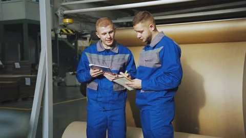 Workers at factory stand next to working production line, conveyor for Video stock 280789841
