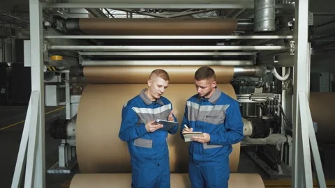 Workers in factory tech facility producing corrugated cardboard. A worker at Stock Footage 280789879