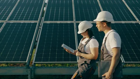 Workers in a field with solar panels walking and talking near the panels Stock Footage 256108525