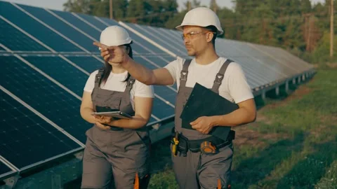 Workers in a field with solar panels walking and talking near the panels Stock Footage 257133615