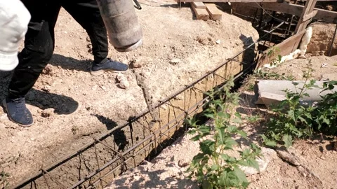 Workers fill the reinforced foundation with cement mortar using a pump Stock Footage 201333764