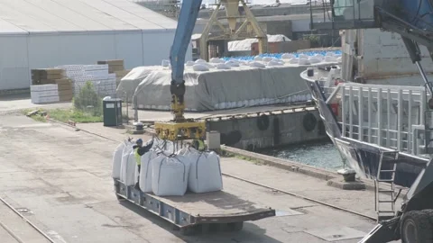Workers fix ropes on crane and mineral fertiliser bags Stock Footage 148389267