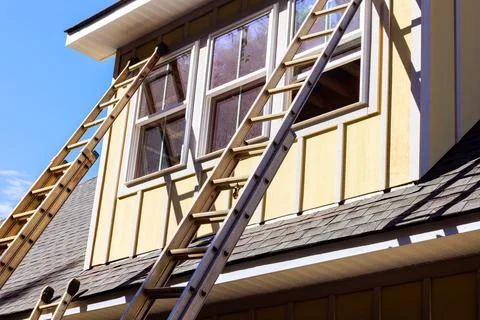 Workers fix window on house at using ladders for construction project 스톡 사진