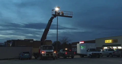 Workers Fixing a Light in a Parking Lot - Wide Shot Stock Footage 82552555