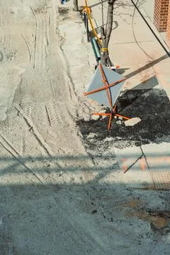Workers focus on repairing the road while barriers mark the construction area Stock-Fotos