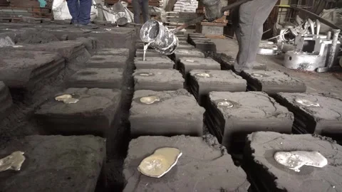 Workers in a foundry pouring liquid Aluminum to a sand cast Stock Footage 245474681