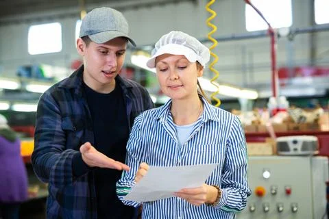 Workers of fruit storage and sorting facility talking about work process Stock Photos