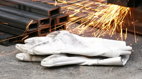 Worker's gloves and splashes of sparks in the workshop Stock Footage 68858351