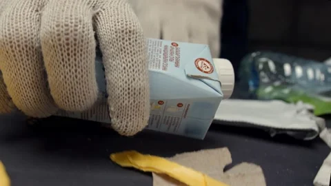 Workers in gloves sort trash selecting tetrahedral packages Stock Footage 144489156