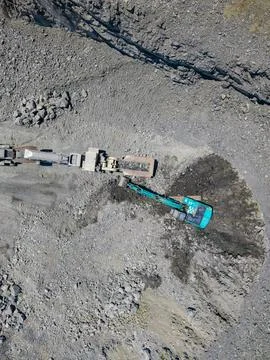Workers in a granite quarry use heavy machinery to extract rocks and stones.. Stock Photos