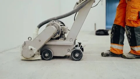 Workers grind the concrete floor at the construction site. Stock Footage 152340769